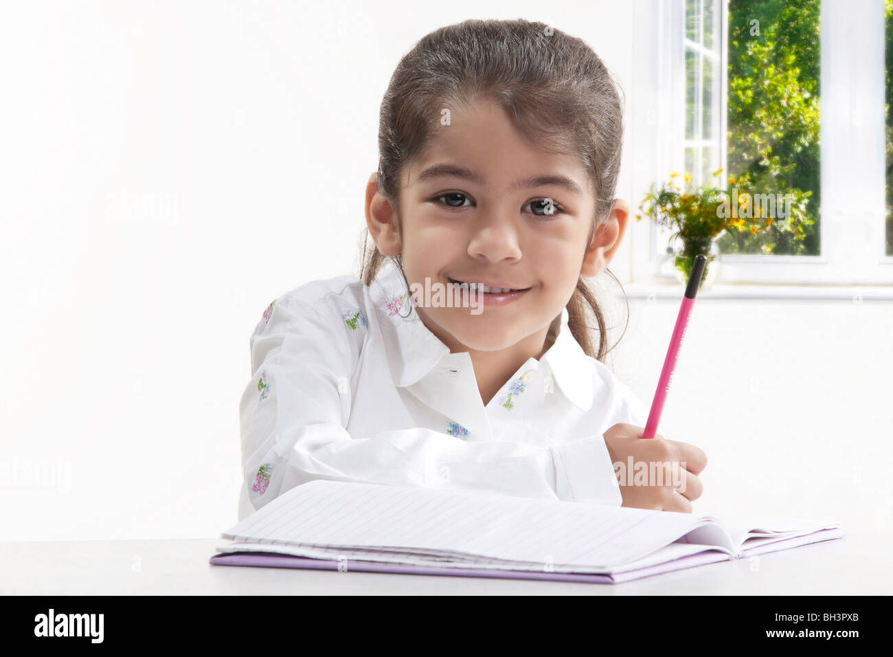 Girl with a book and pencil Stock Photo - Alamy