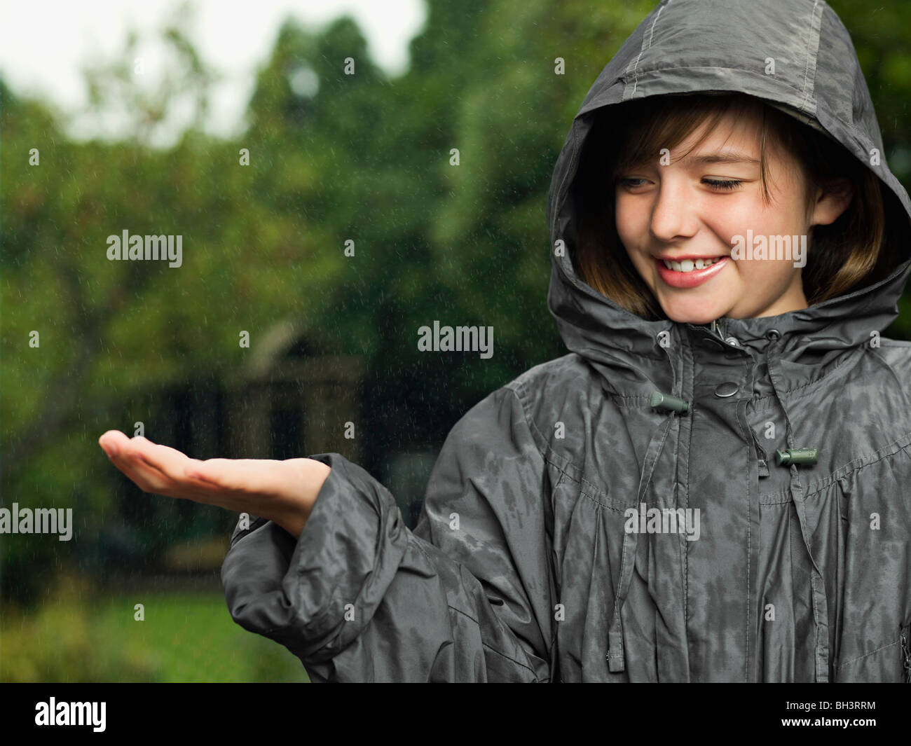 Girl holds hand out to catch rain Stock Photo Alamy