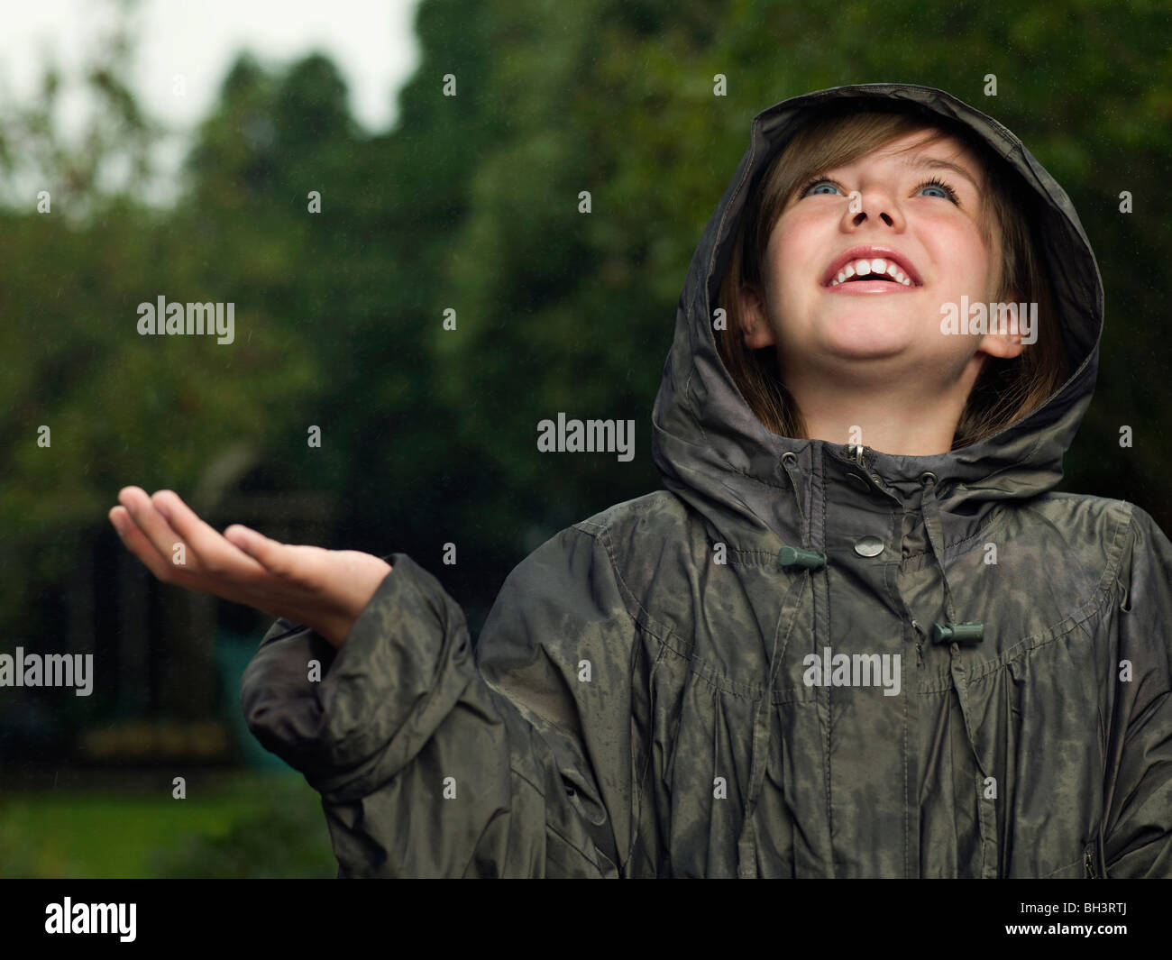 Girl holds hand out to catch rain Stock Photo Alamy