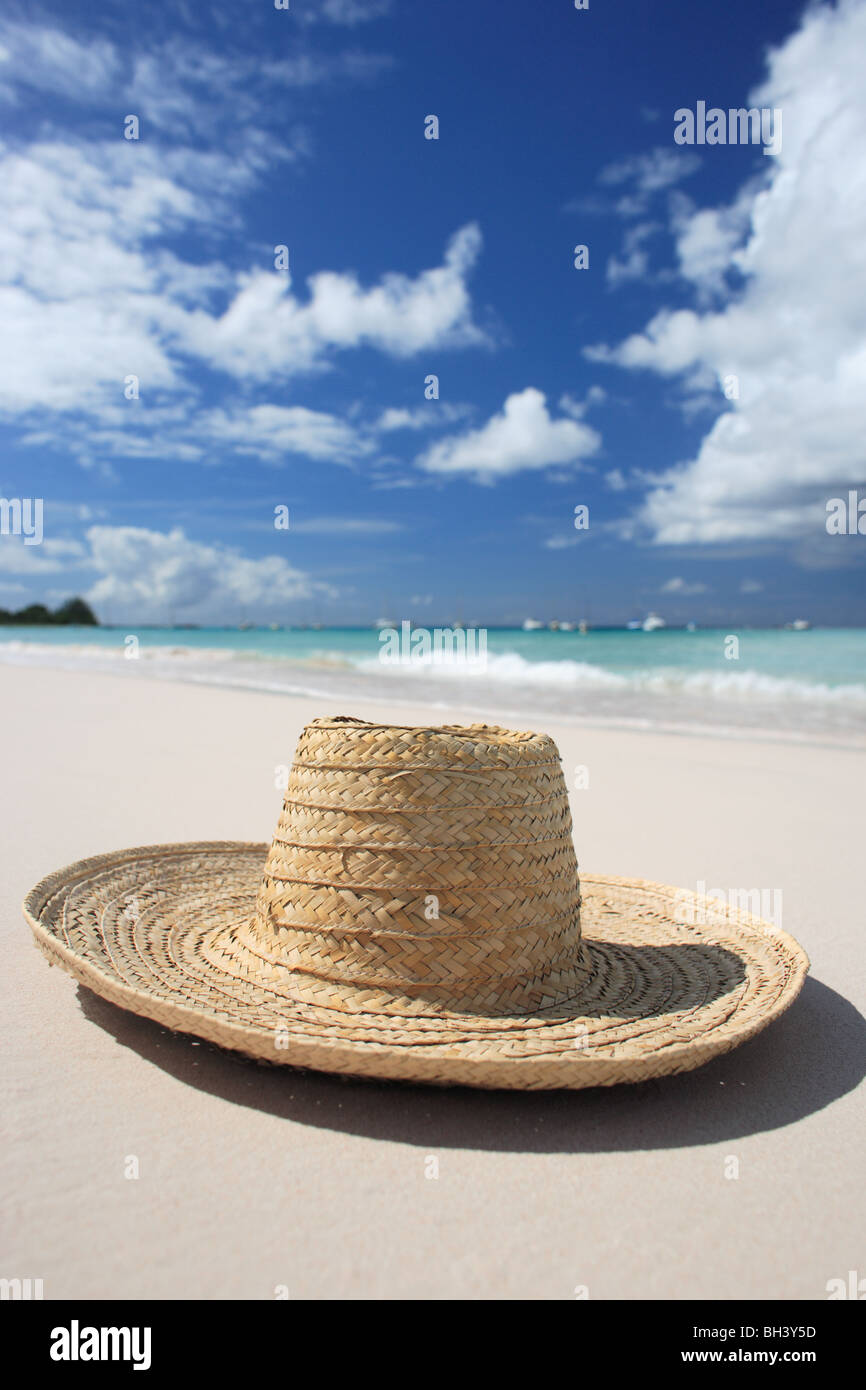 A straw hat lying on the sand on a deserted tropical beach Stock Photo ...