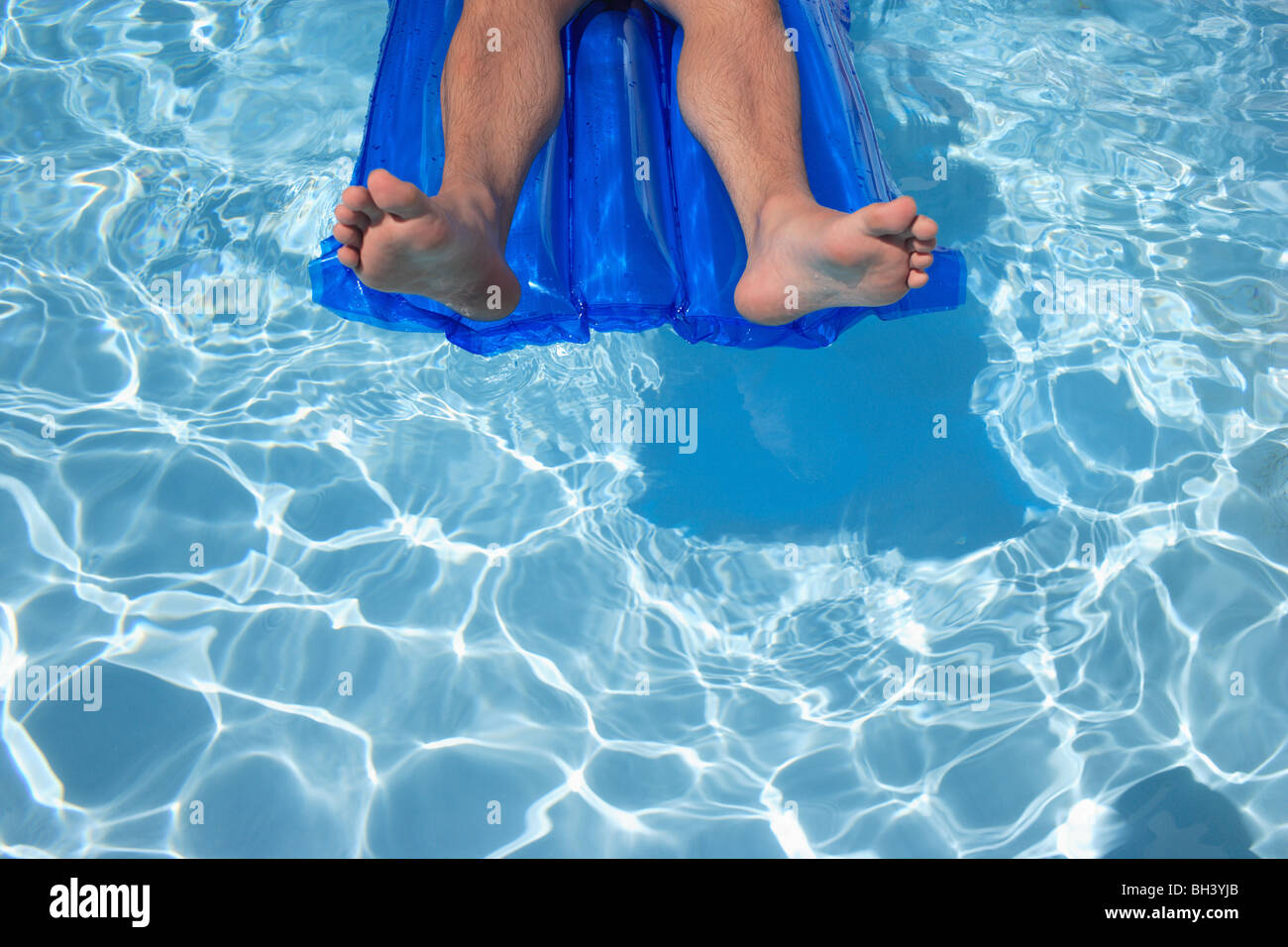 Close up of a man's legs and feet relaxing on an inflatable lilo air