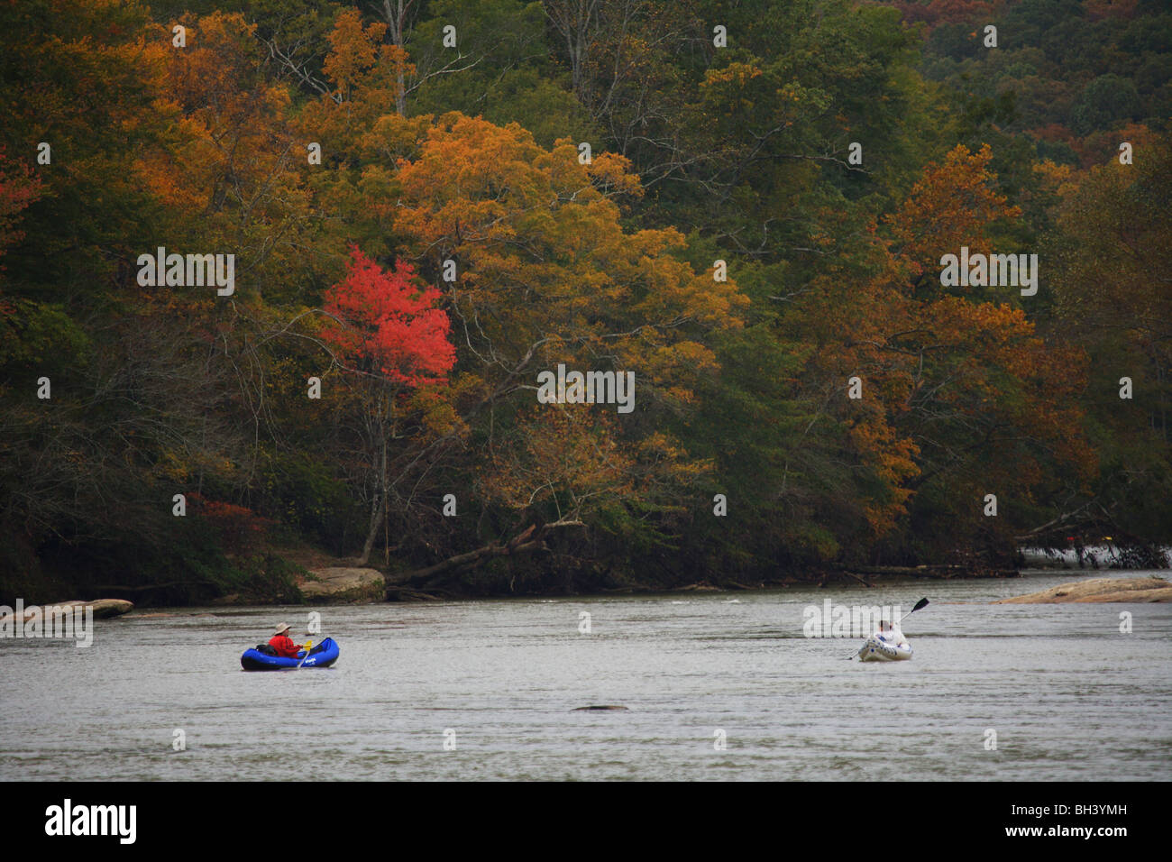 KAYAKER(S) INFLATABLE KAYAKS PADDLING A RIVER ENJOYING THE FALL COLOR IN THE TREES GEORGIA WIDE ANGLE NO MODEL RELEASE Stock Photo