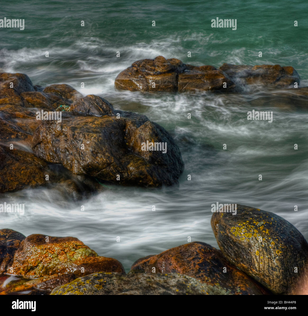 Colourful rocks, pebbles and seawater on shore near harbour of Aberdeen ...