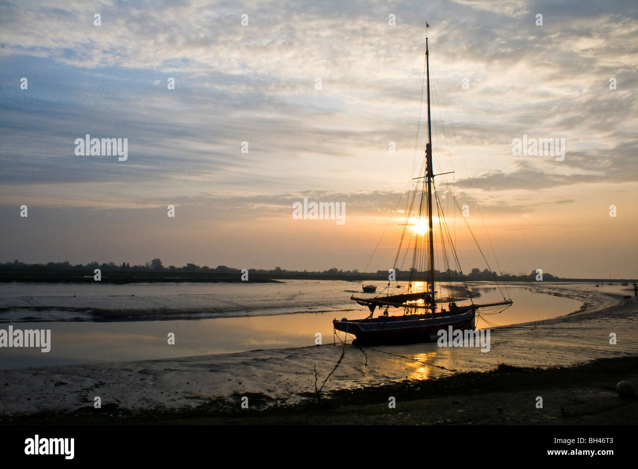 Oyster smack silhouetted against the early morning sun at Maldon, Essex. Stock Photo
