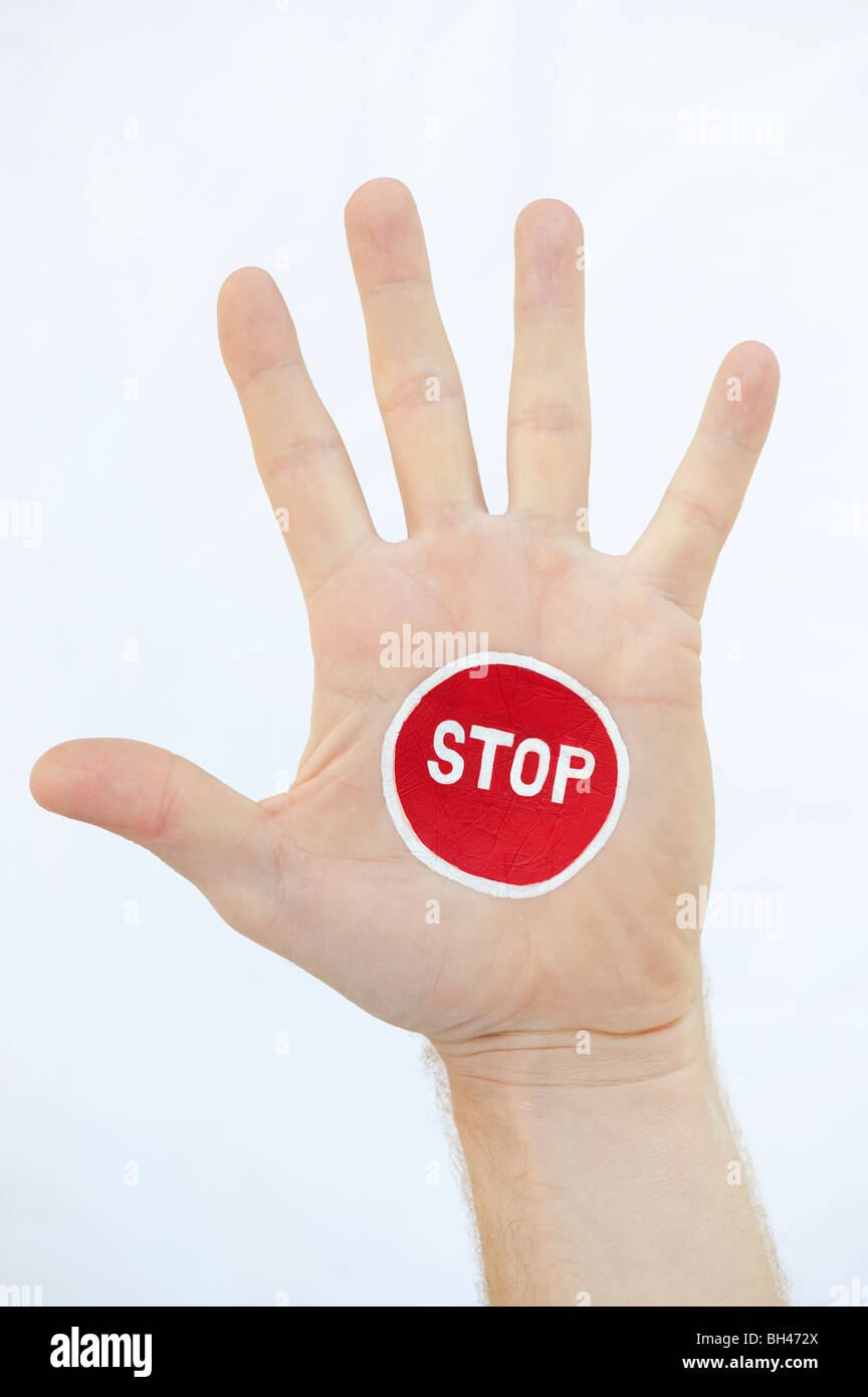 Painted STOP sign on hand against white background Stock Photo