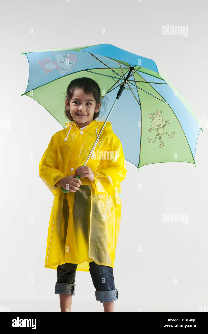 Girl wearing a raincoat and holding an umbrella Stock Photo - Alamy