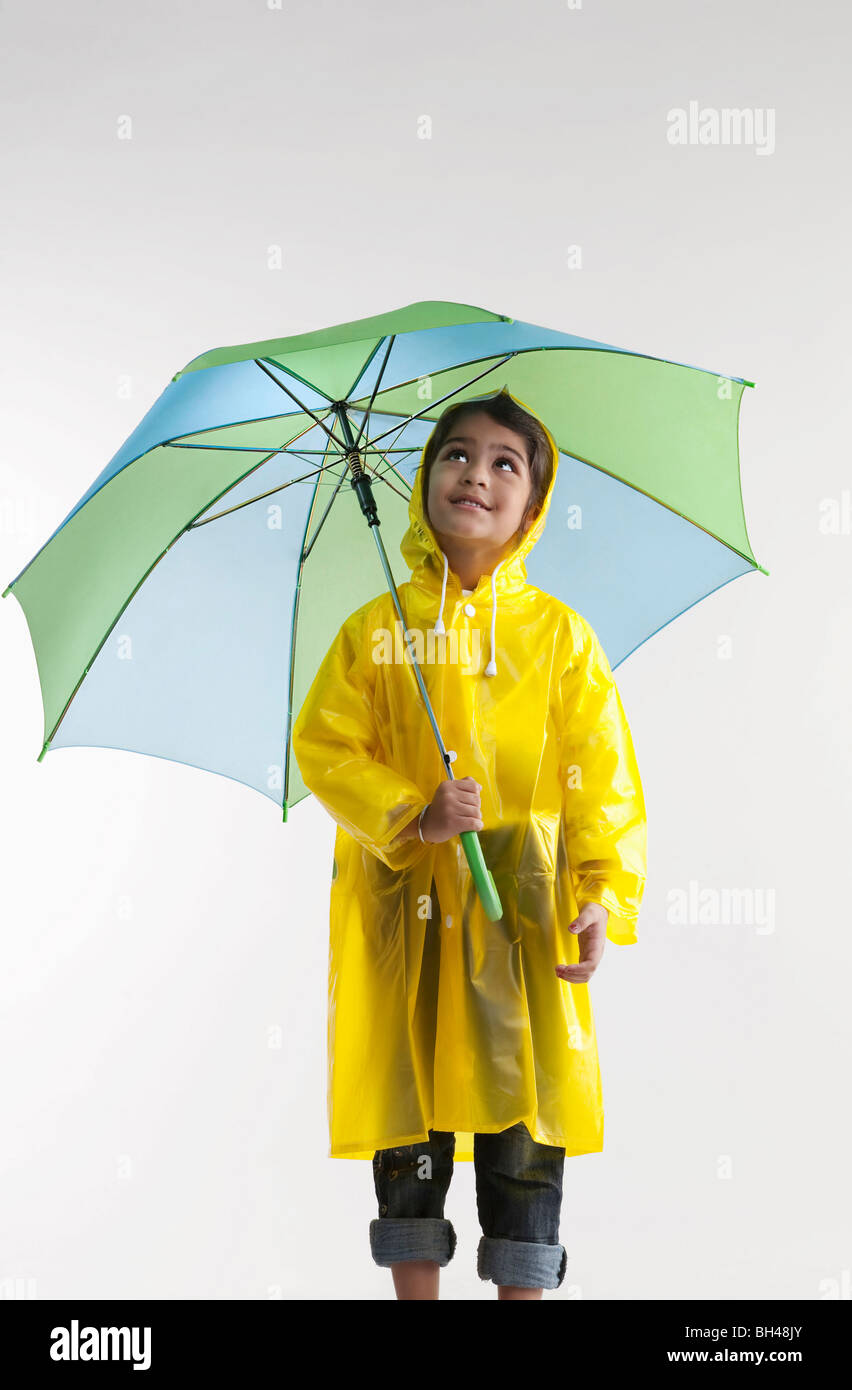 Girl wearing a raincoat and holding an umbrella Stock Photo Alamy