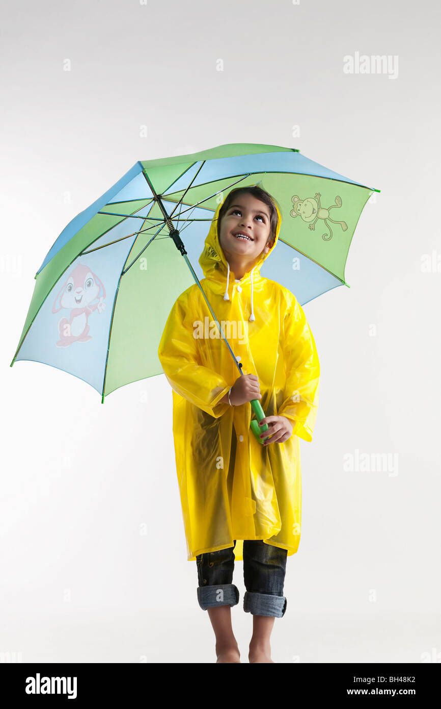 Girl wearing a raincoat and holding an umbrella Stock Photo Alamy
