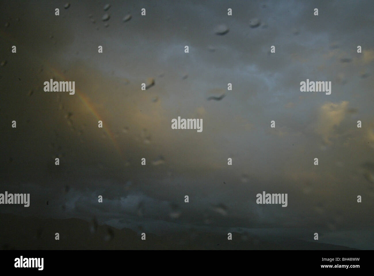 A rainbow seen from hotel window covered by rain in Salt Lake City