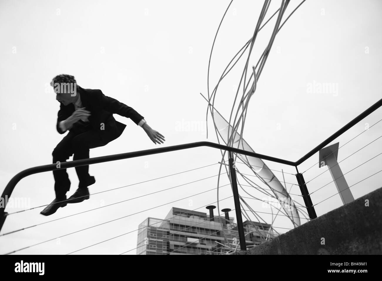Young businessman jumping down a staircase in the city Stock Photo