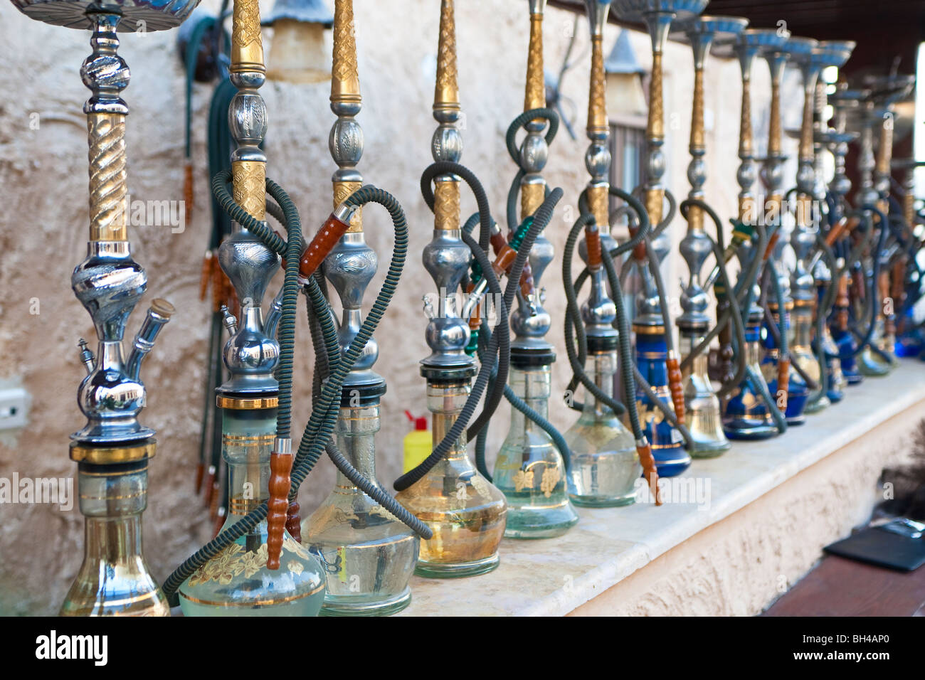 Arabic shisha, sometimes called hookah, waterpipes lined up on a bar for customers in a restaurant in an Arabic country. Stock Photo