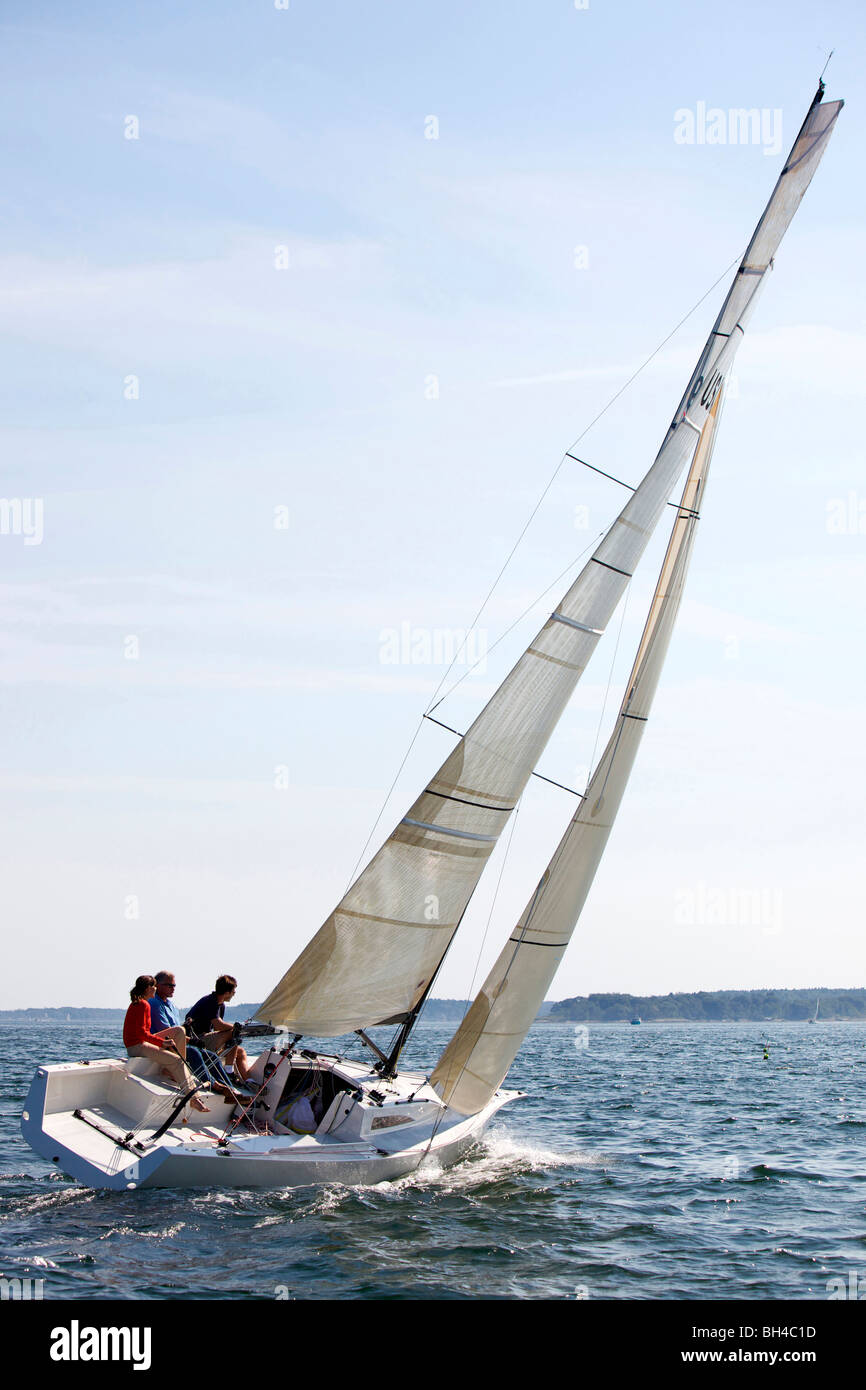 Three adults enjoying a sunny day on board a daysailer on Casco Bay, Maine. Stock Photo