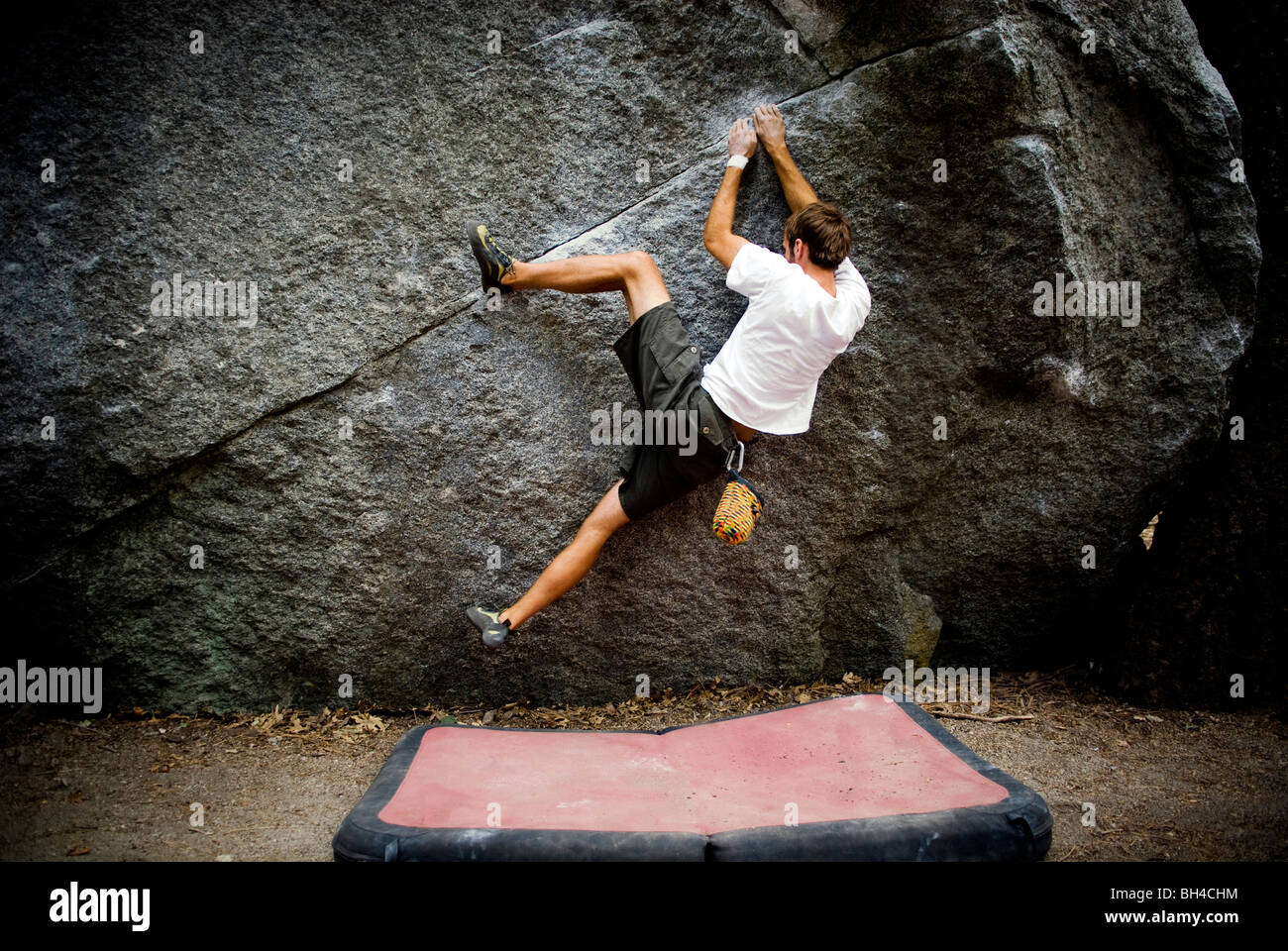 A young man's heal hooks a boulder located in Yosemite Valley, California. Stock Photo