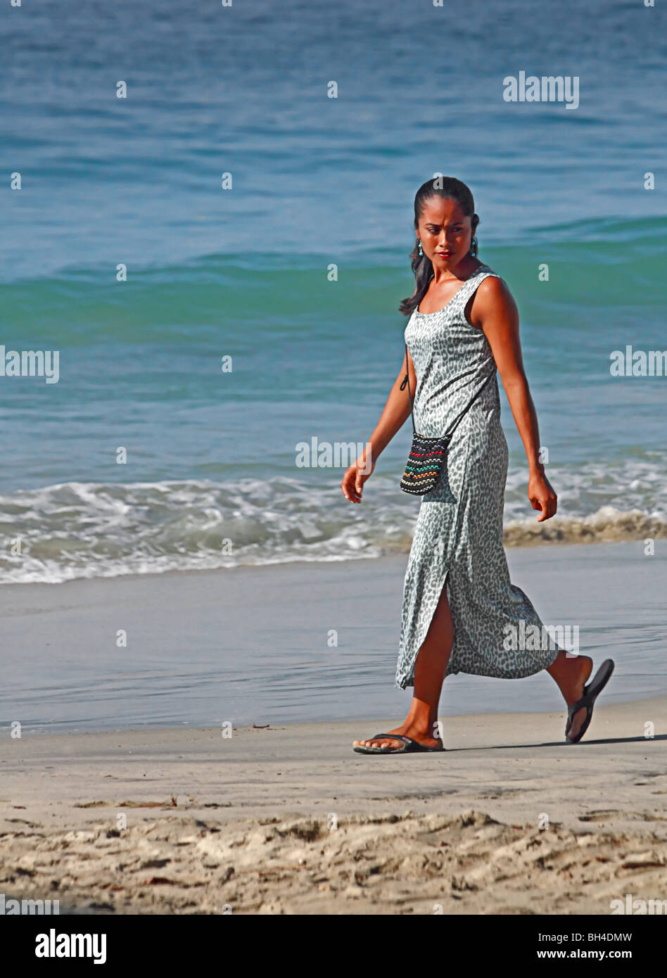 Beautiful Mexican lady strolling on Puerto Escondido beach, Mexico Stock Photo