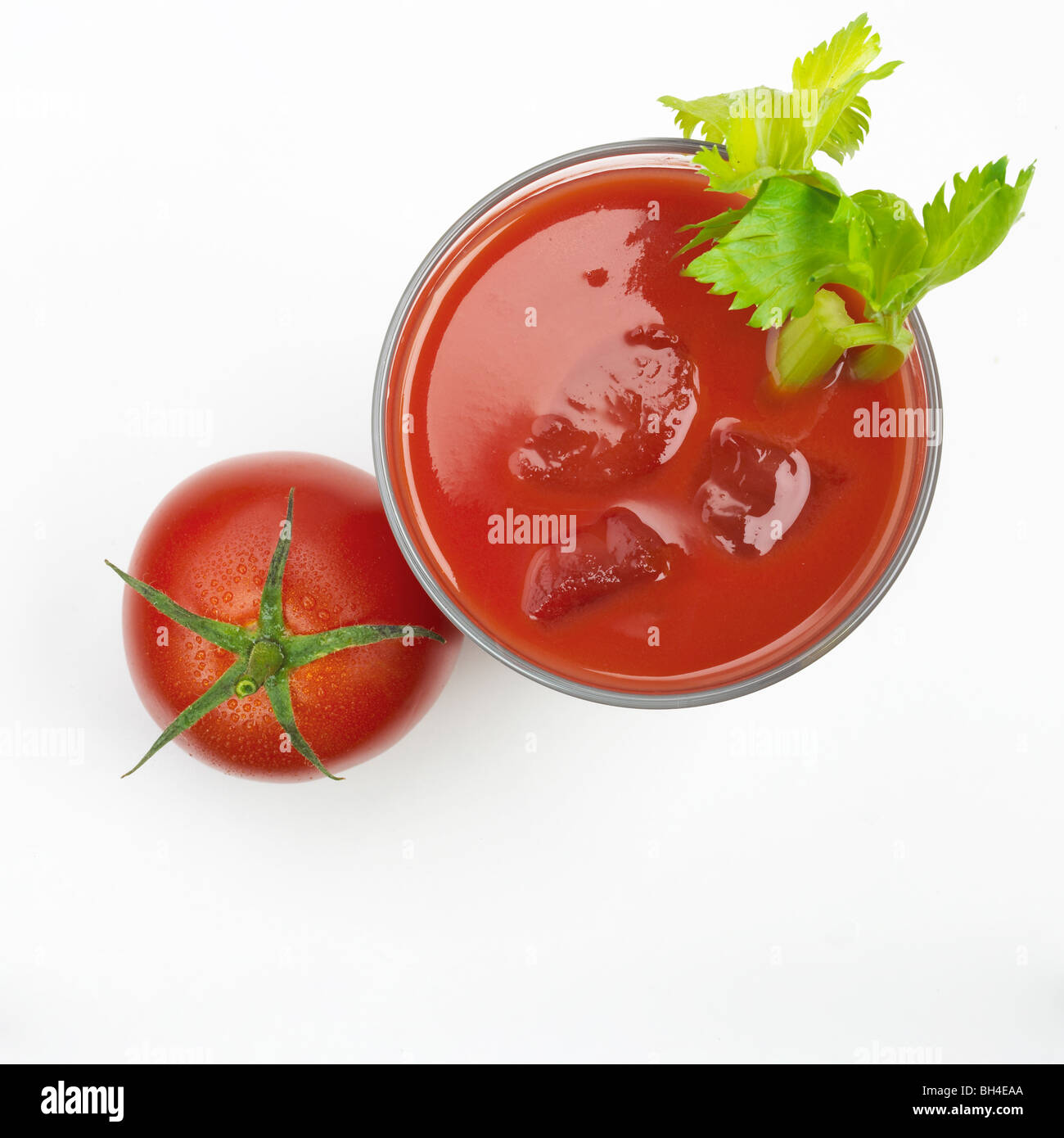 Glass of tomato juice and a whole tomato on a white background Stock Photo