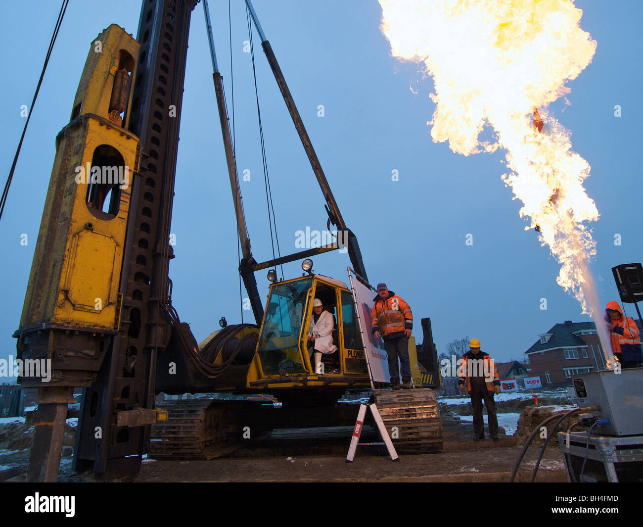 Ceremony at the start of a new building project, first pole being driven into the ground, large flame shooting up in the sky. Stock Photo
