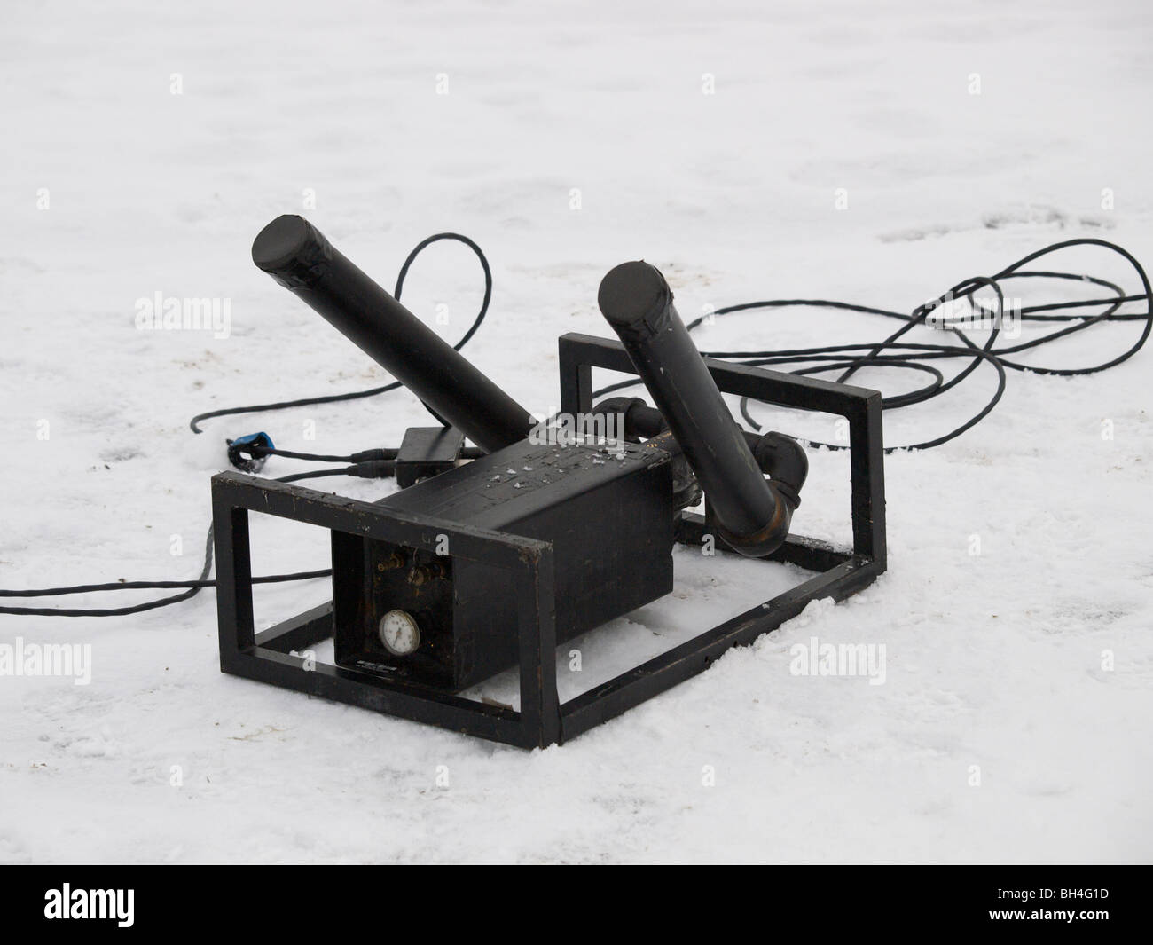 Professional confetti gun that works with compressed air, lying outside in the snow. Barrels can be aimed individually. Stock Photo