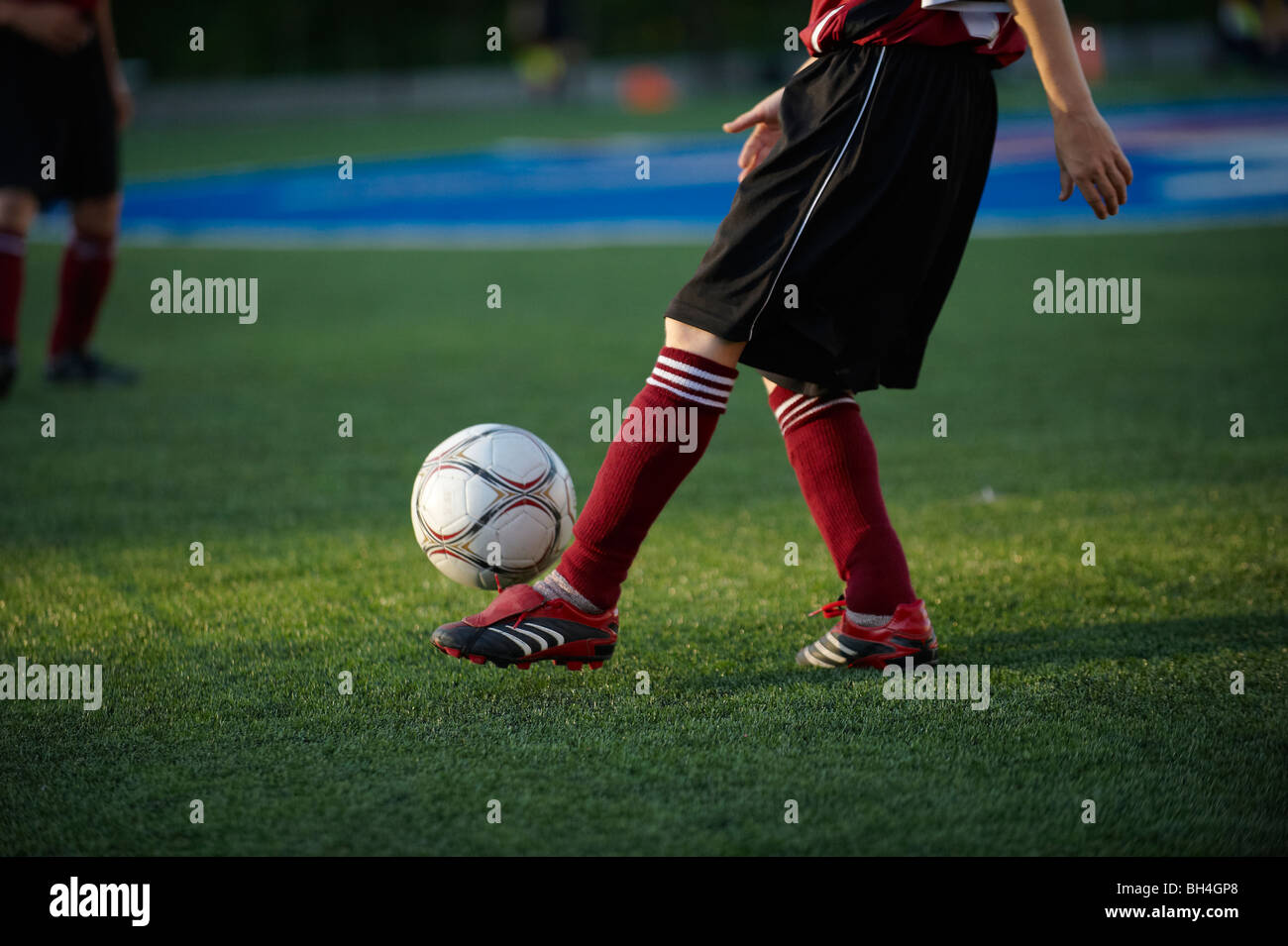 Young boy kicking ball before soccer match Stock Photo