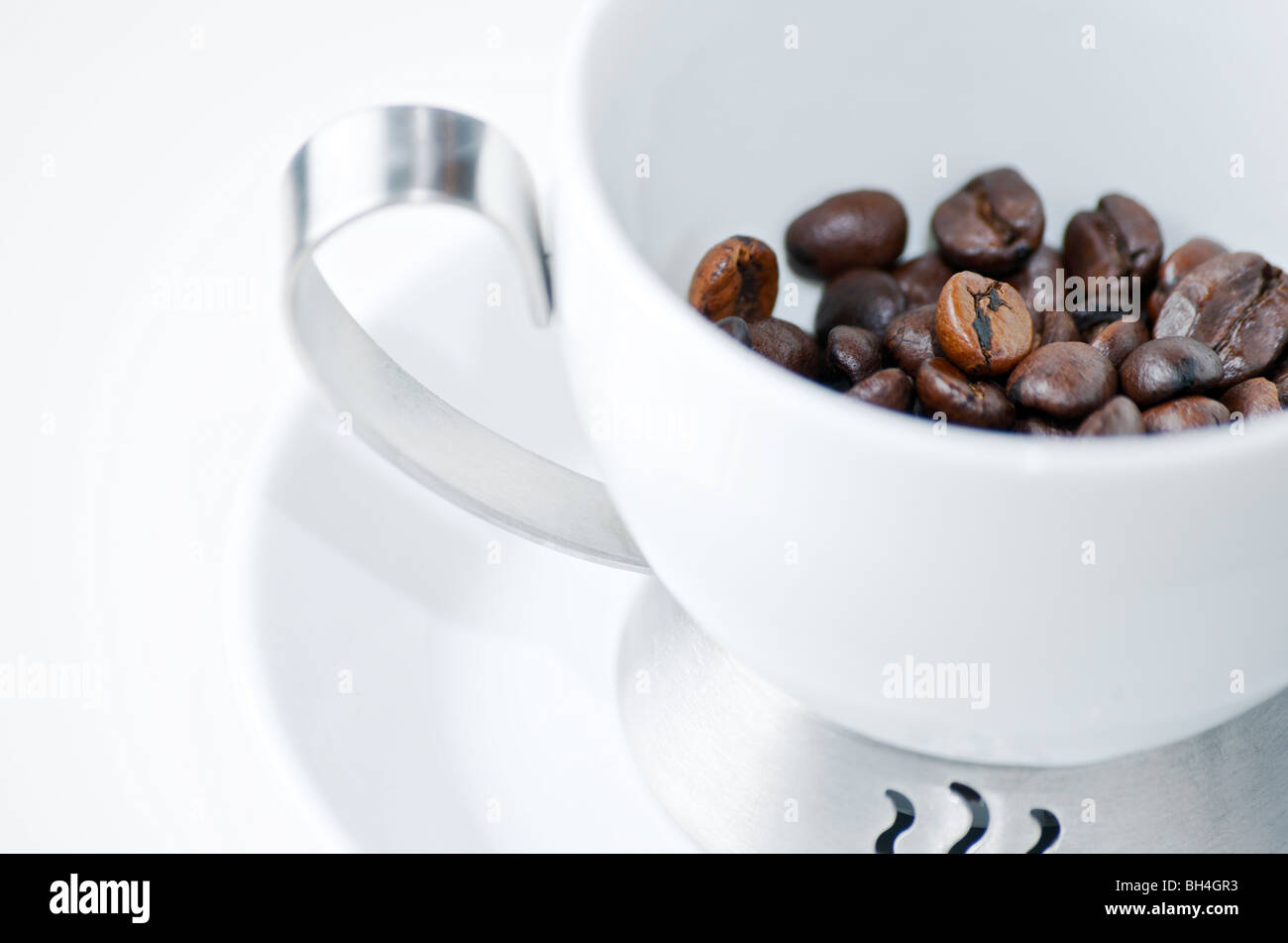 Whole roasted coffee beans in white porcelain espresso cup, Otterburn