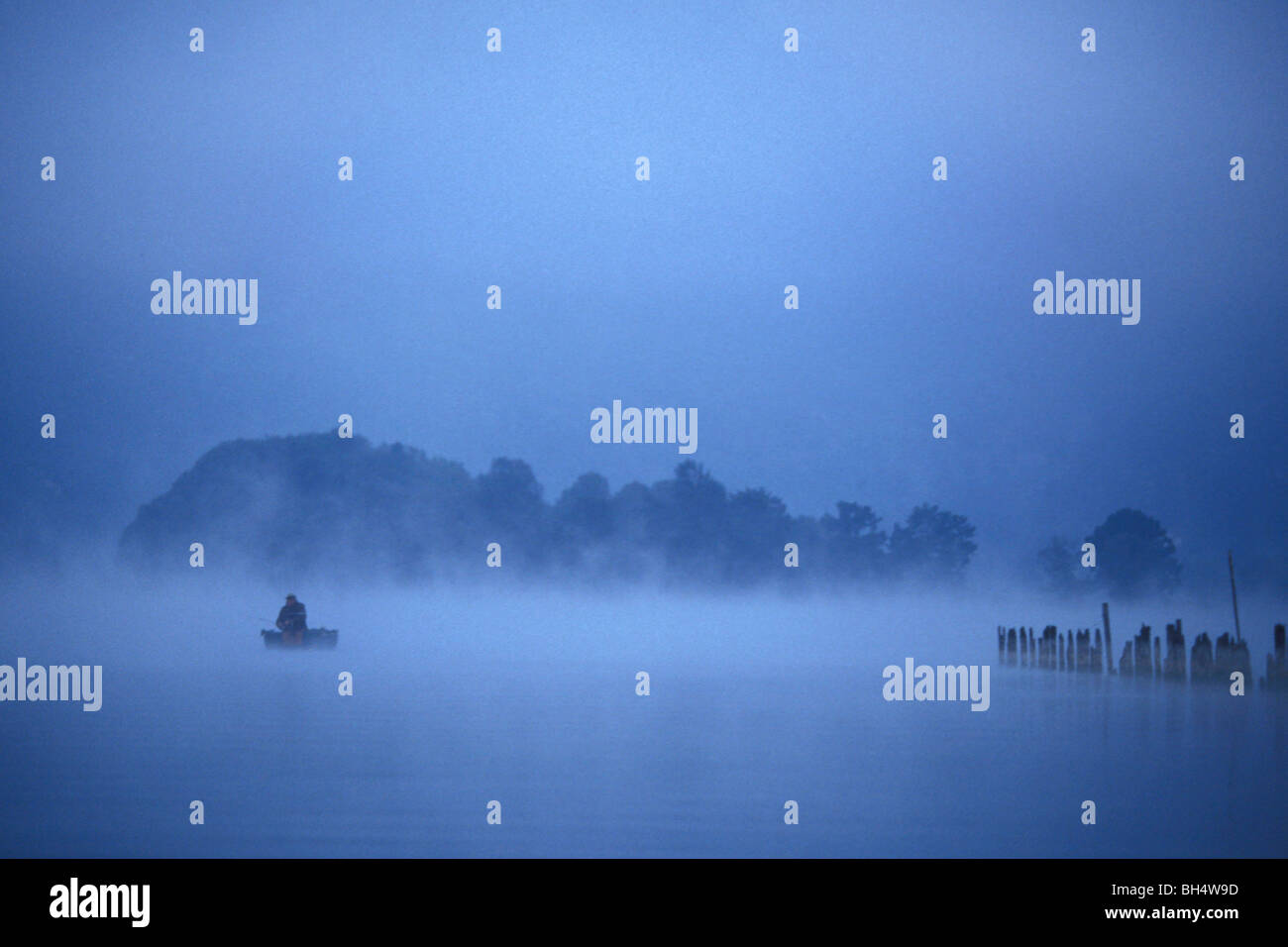 FISHERMAN IN THE MORNING MIST, AIGUEBELETTE LAKE, SAVOY (73), FRANCE Stock Photo