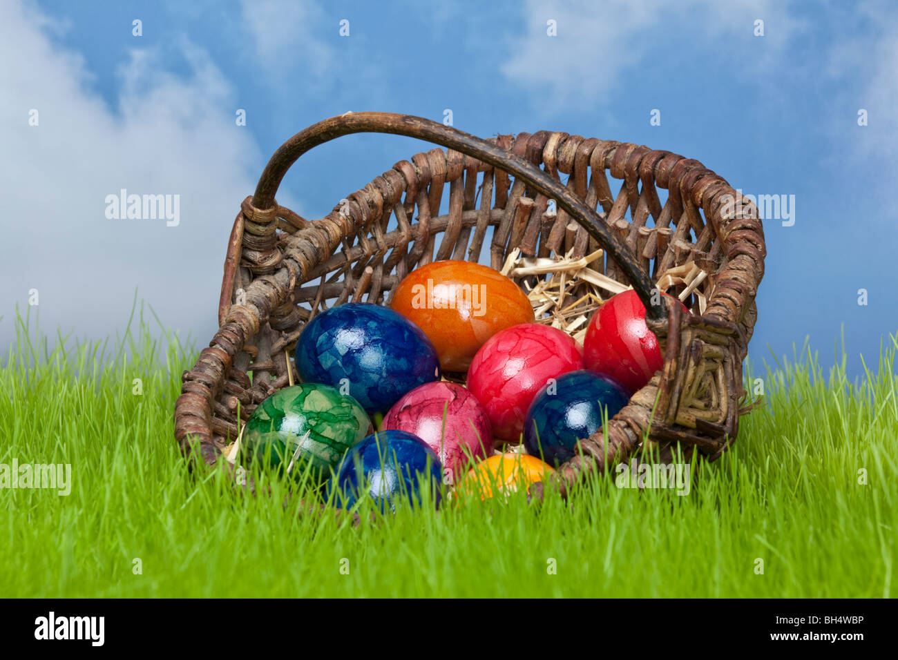 easter eggs in a basket on the grassland with the heaven in the background Stock Photo
