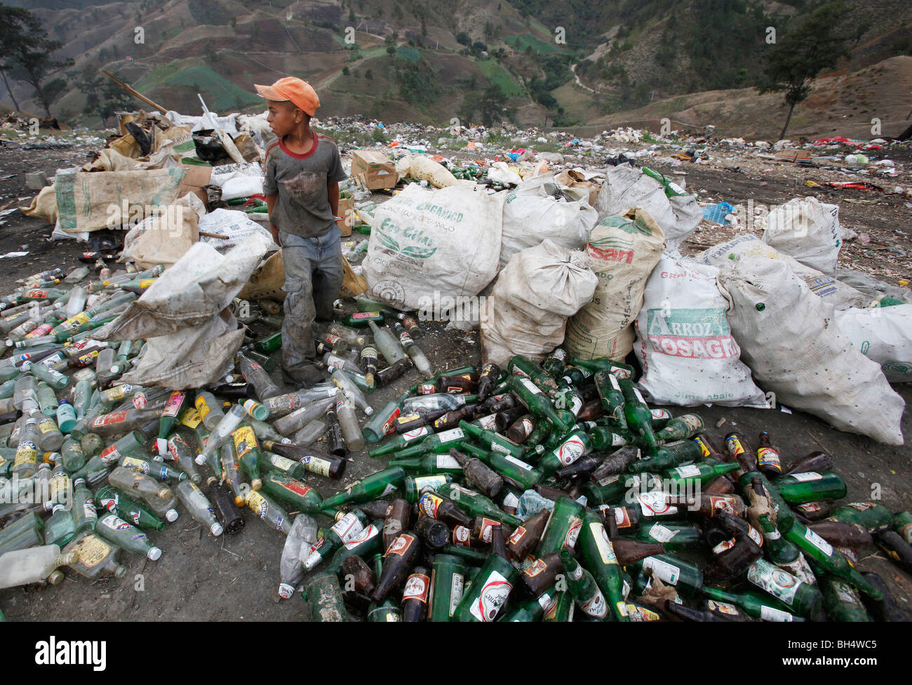 A boy scavenges bottles at a trash disposal area outside of Constanza, Dominican Republic Stock Photo