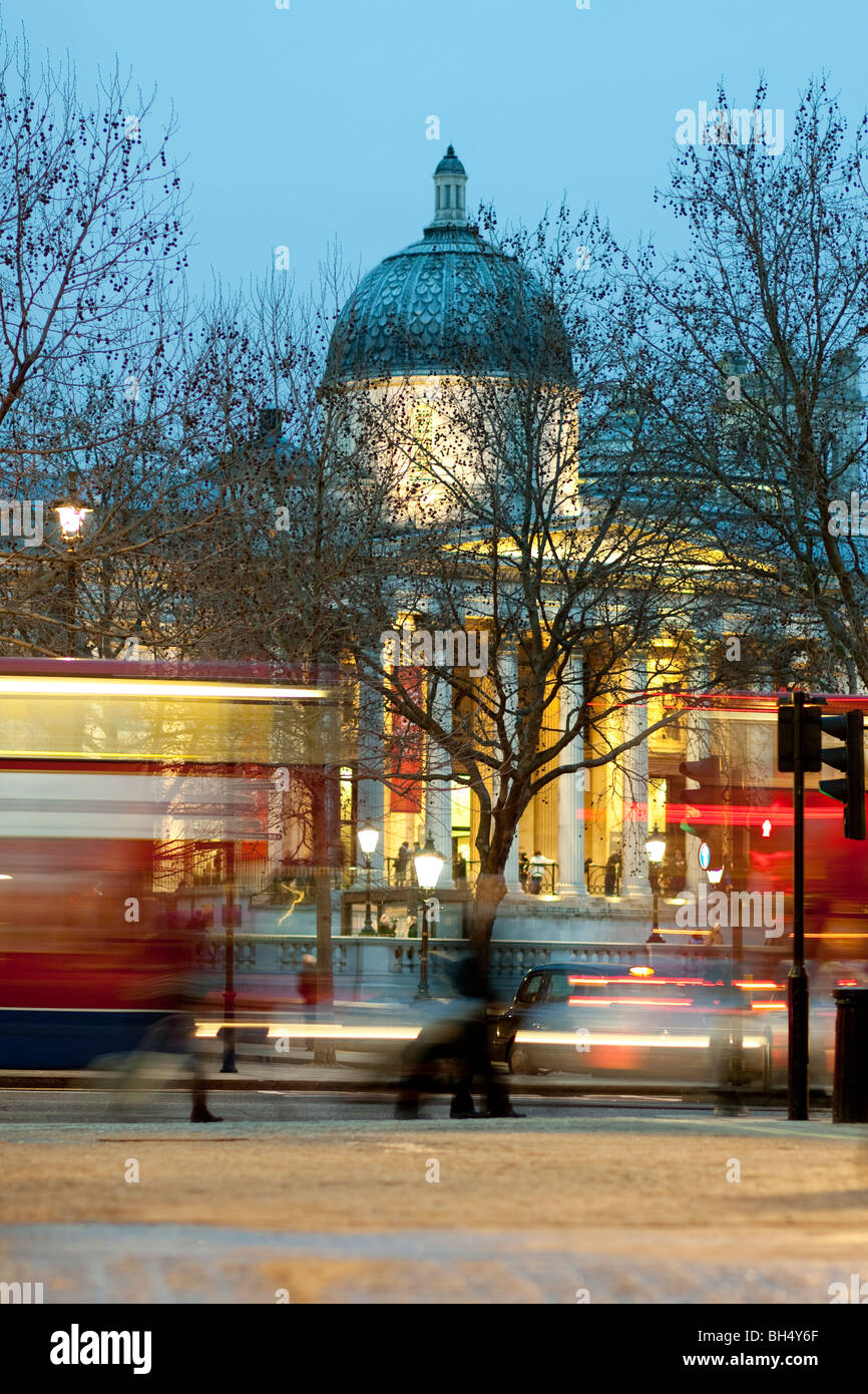 National Gallery and Trafalgar Square and blurred motion double decker red buses at night Stock Photo