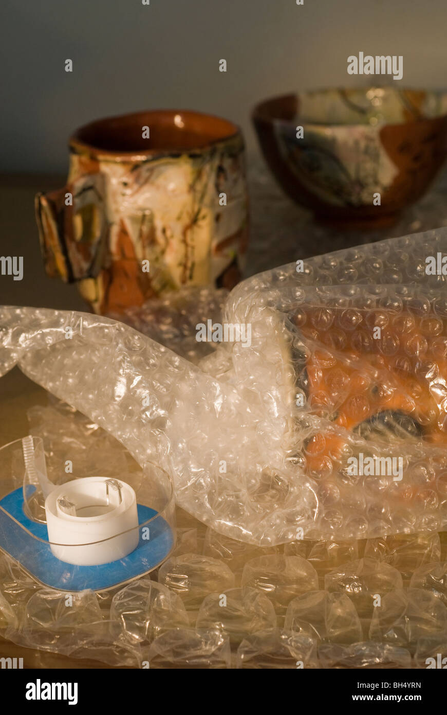 Pottery is wrapped in bubble wrap prior to being shipped Stock Photo