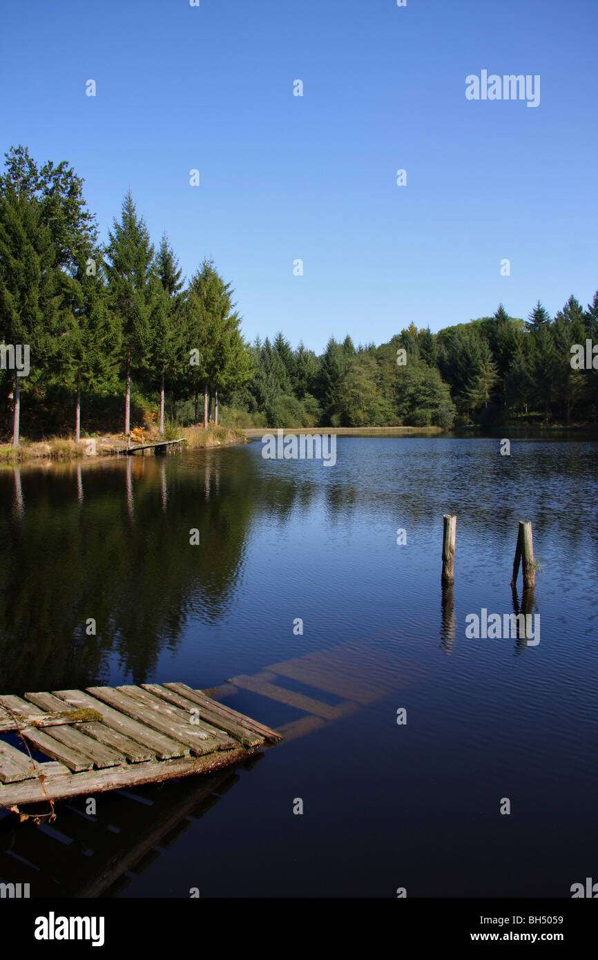 A pretty lake with two old collapsed jetties on a bright sunny day. Stock Photo