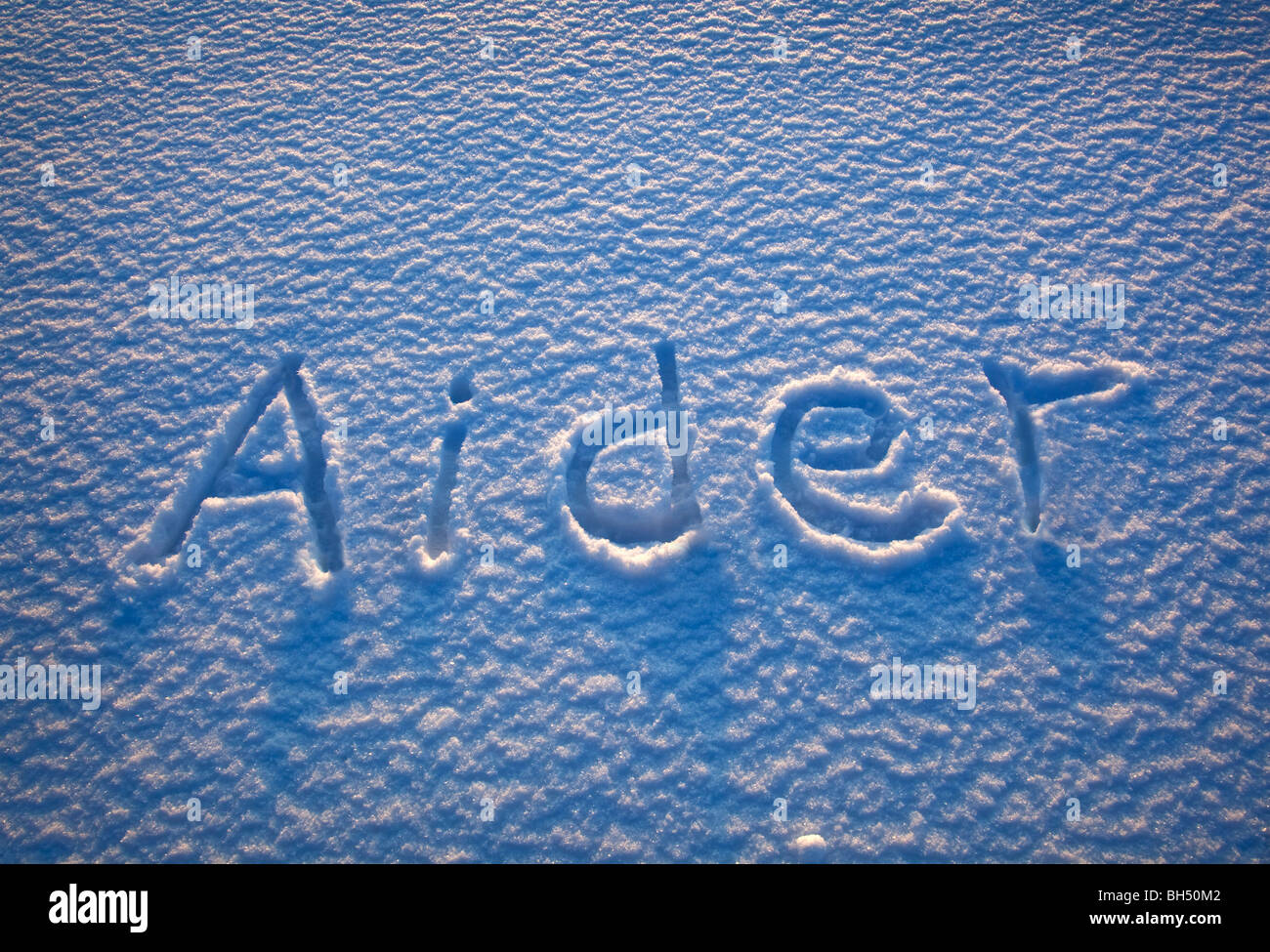 The French word for 'help' spelled out in the snow Stock Photo