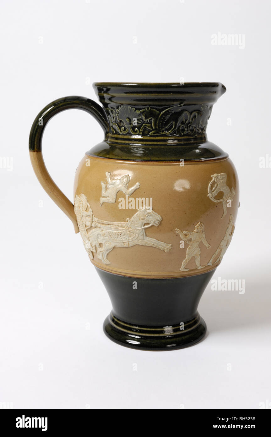 An 8 inch high English Doulton stoneware pottery jug depicting an Assyrian war chariot charging the foe. Probably late 19th C. Stock Photo