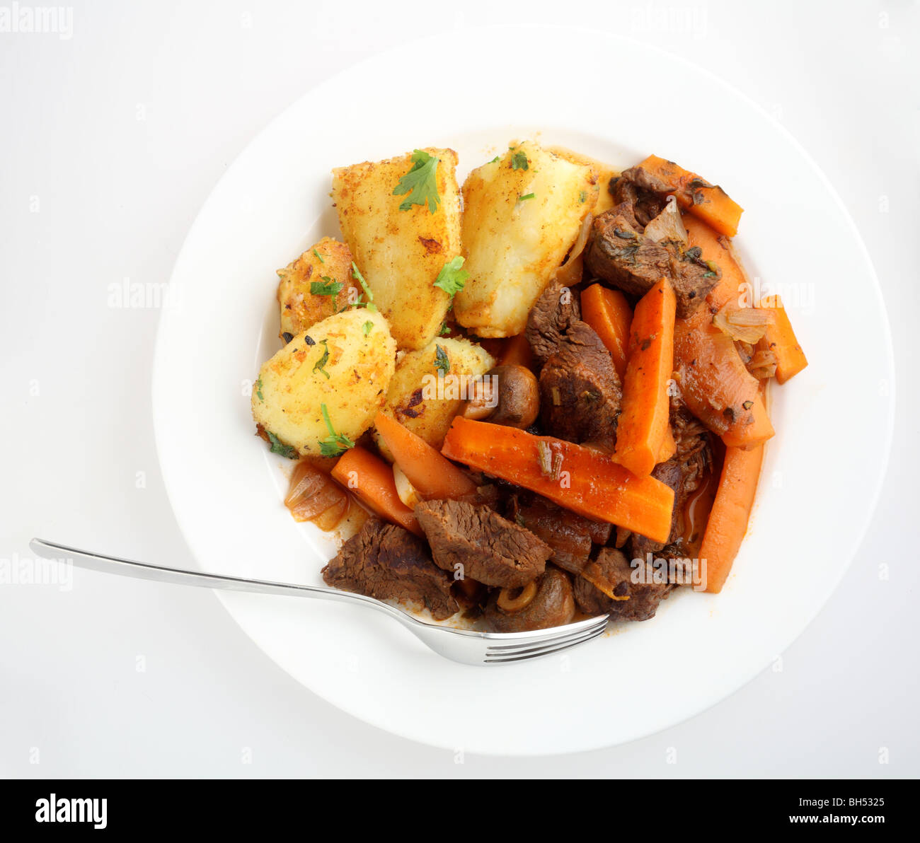 Top view of a plate of beef and carrot stew with a fork Stock Photo