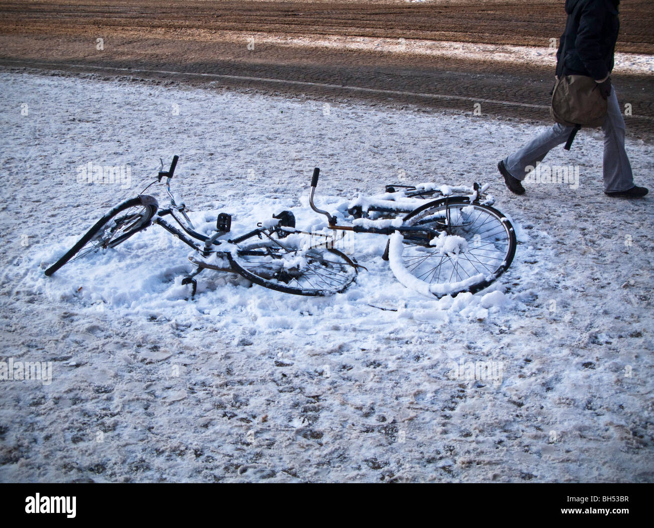 Abandoned bicycles lying on snow covered square, Amsterdam Stock Photo