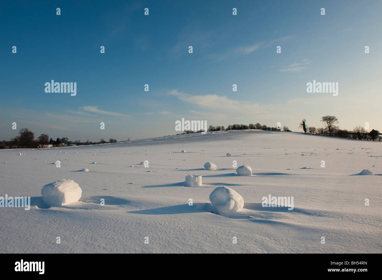 Wind blown snow balls or 'snow donuts' or 'snow rollers - a rare meteorological phenomenon in a field at Charlton, Hitchin UK, Stock Photo