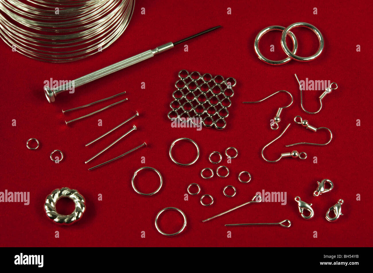 rings, wire and other items for crafting jewelry on red background Stock Photo