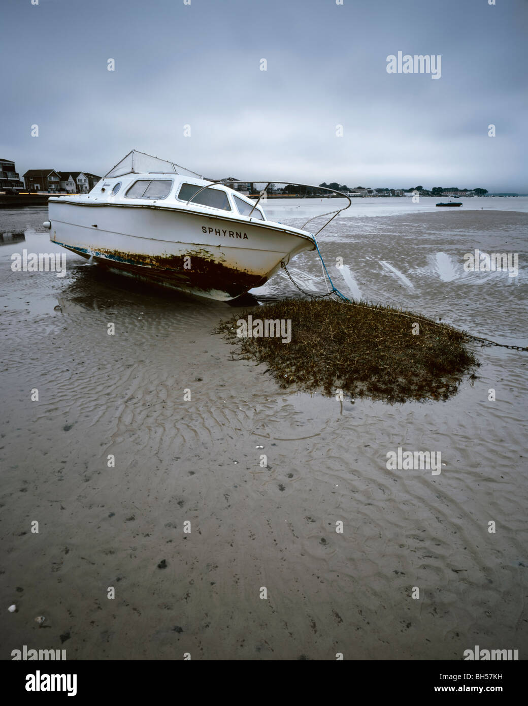 Boat on the sand in the bay of Poole in Dorset, UK, with the Sandbank visible in the background Stock Photo