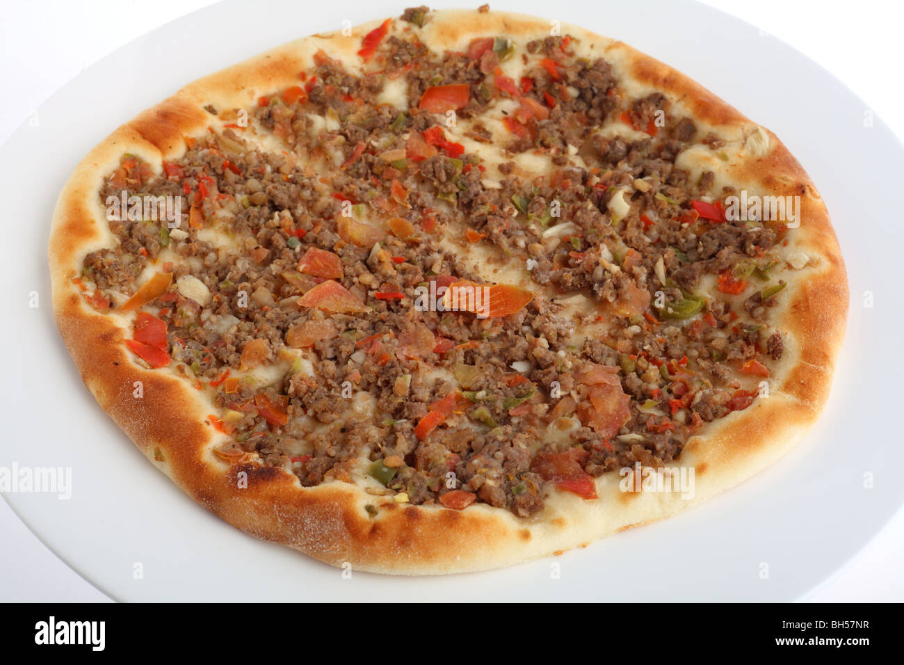 A fataya Arab bread, topped with meat and vegetable sauce before baking. Stock Photo