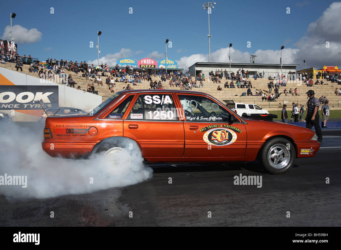 Australian Holden Commodore drag racing car performing a burnout to warm the rear tyres before racing Stock Photo