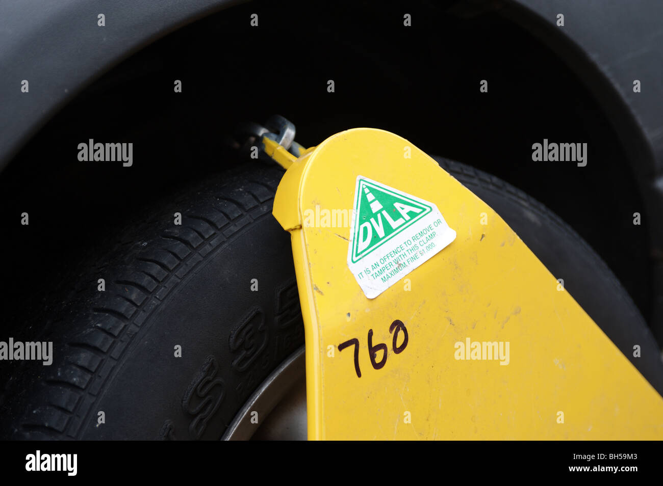 A wheel clamp fitted to a car by the DVLA to a car without a valid TAX disc. England, UK, Europe