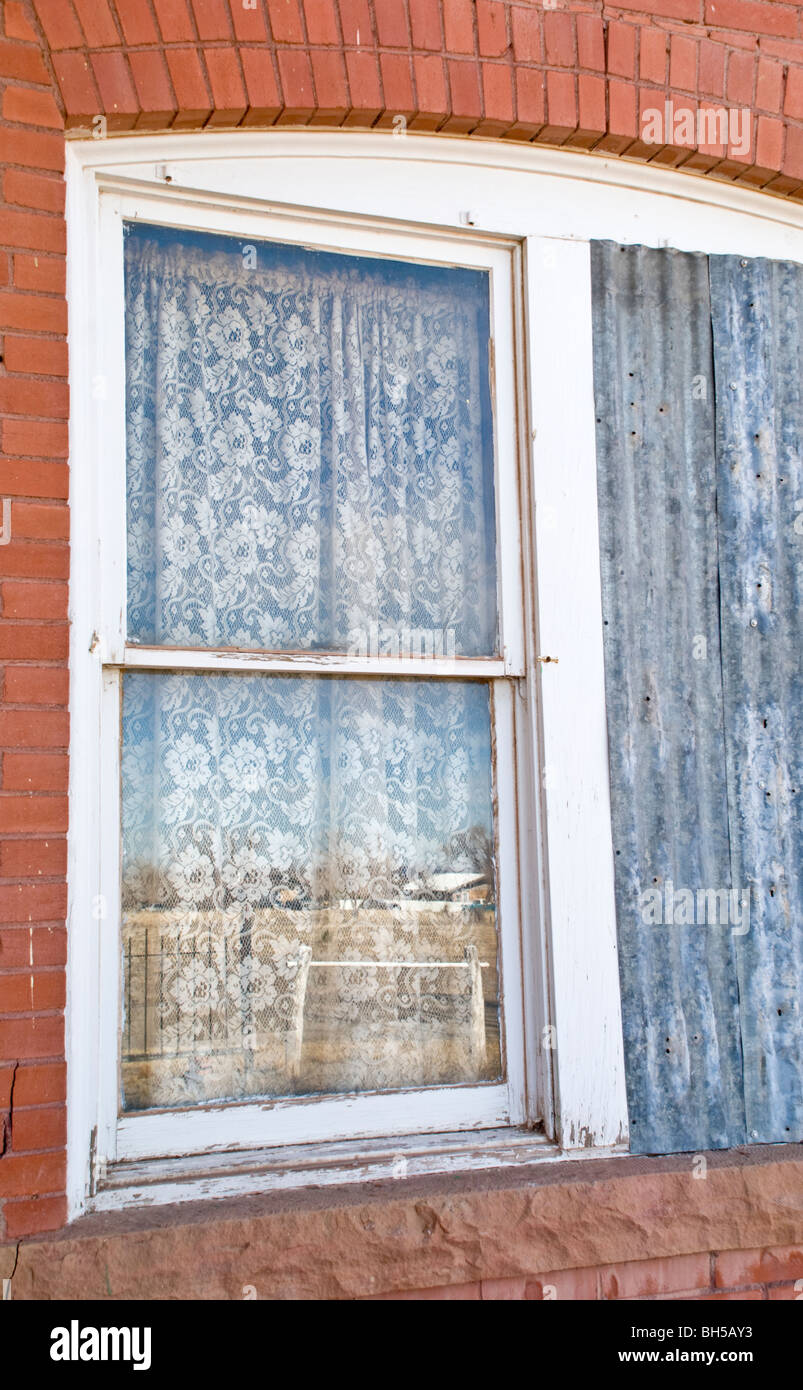 A reflection in the window of a vacant house reveals it's desolate surroundings. Stock Photo