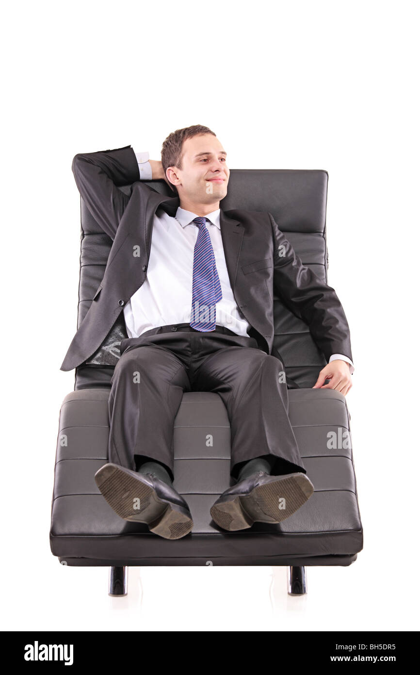 Businessman lying on a black leather sofa Stock Photo