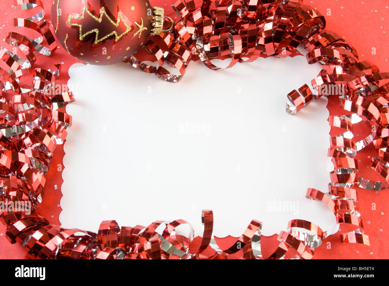 blank Christmas card with metallic red ribbon, ornament, and copy space Stock Photo