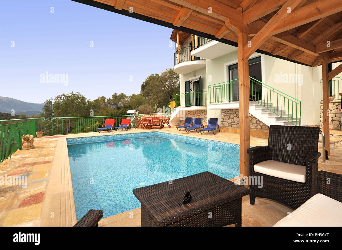 Holiday vacation villa with a private swimming pool. Covered area with a table and chairs to shelter from the sun Stock Photo