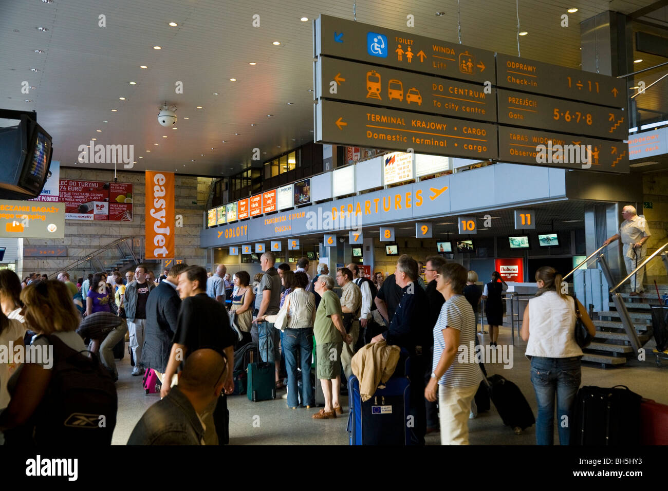 Departing passengers queue in departures check-in hall for checkin at Krakow International Airport (Balice) Krakow, Poland. Stock Photo