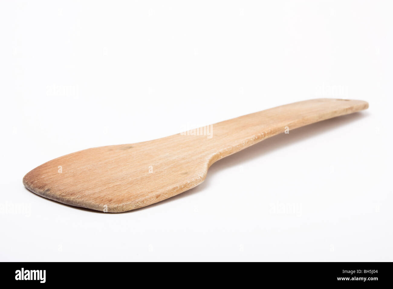 well used wooden kitchen Spatula isolated against white background. Stock Photo
