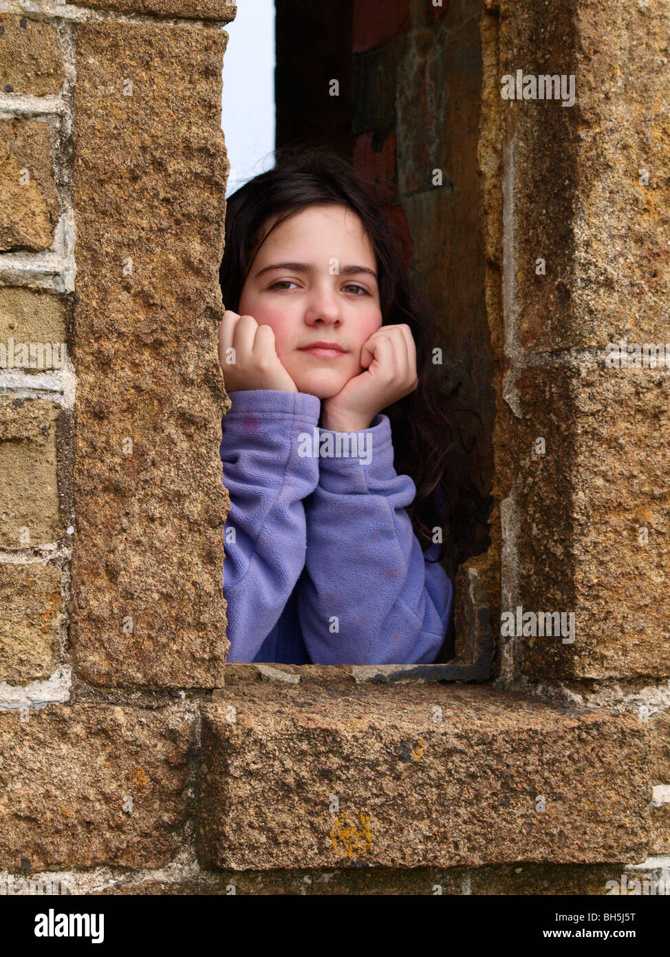 Young girl looking through the window openings Stock Photo Alamy