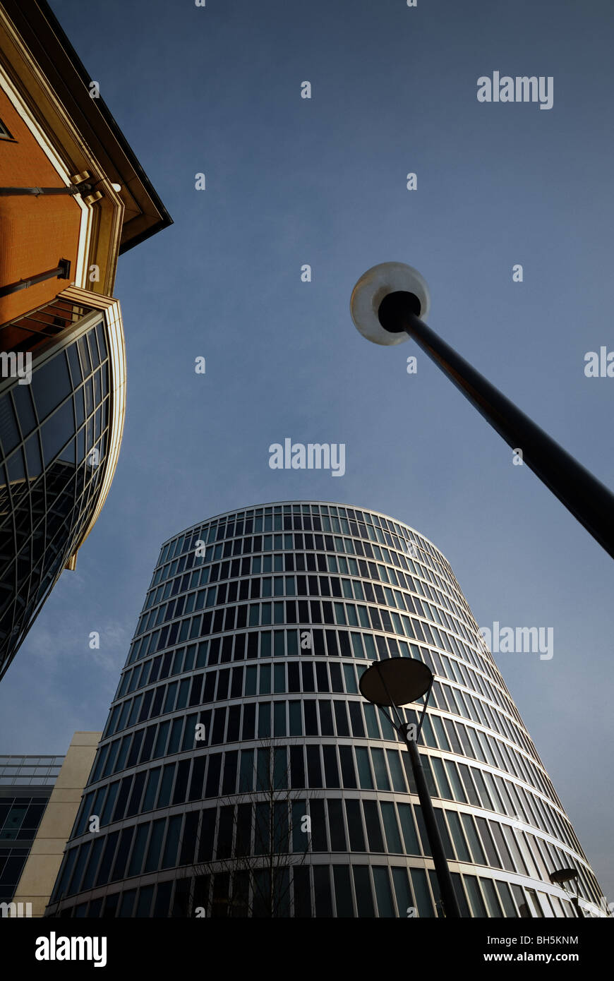 Vertical view of a sky with modern architecture and lamp posts rising up Stock Photo