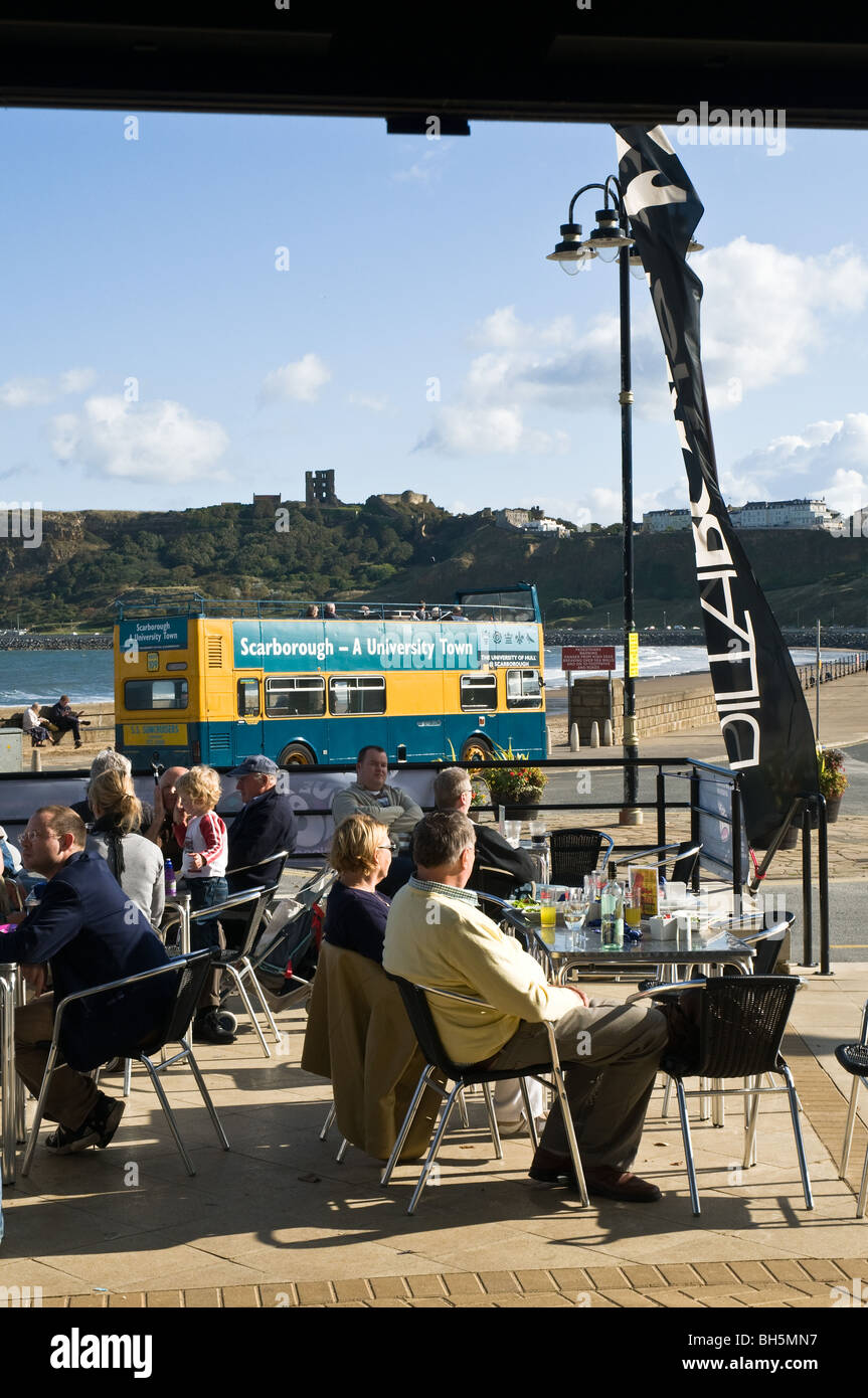dh North Bay corner cafe SCARBOROUGH CAFES NORTH YORKSHIRE UK Customers sitting al fresco holidaymakers english holiday makers alfresco Stock Photo