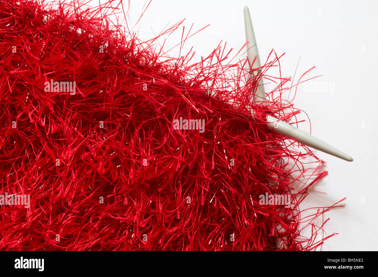 Knitting a scarf with red fluffy wool Stock Photo Alamy