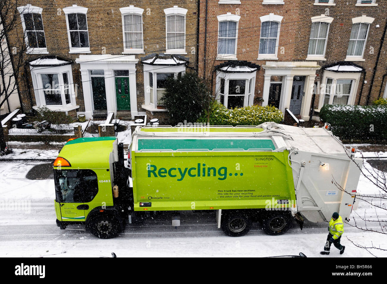 Recycling truck in snow with council worker, Holloway Islington London England UK Stock Photo